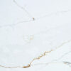 Close-up of Ethereal Calacatta Quartz slab showing gold veining and soft grey movement on a bright white polished surface