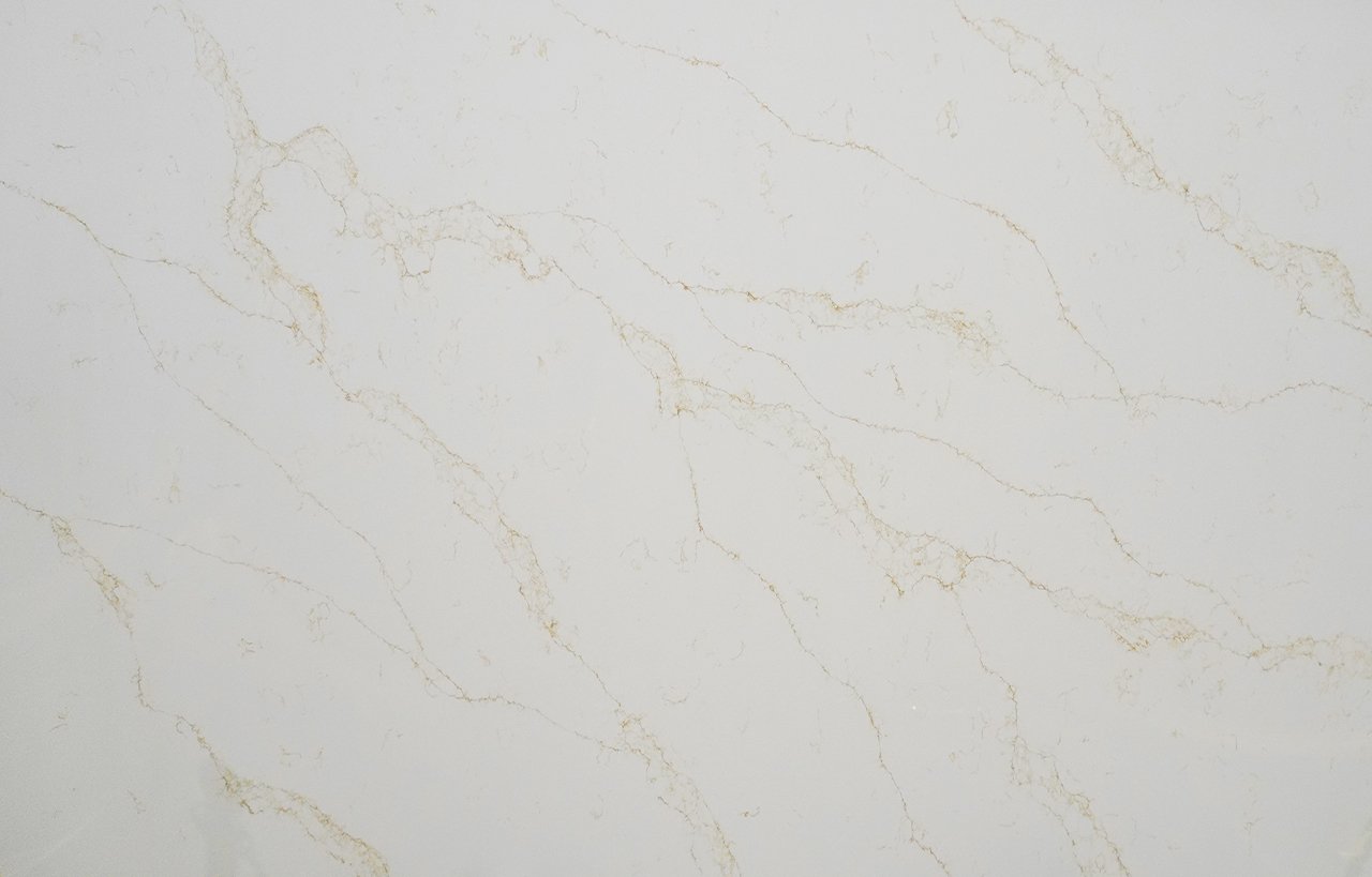 Close-up of Gold Statuario Quartz slab showing fine gold veining on a bright white polished surface