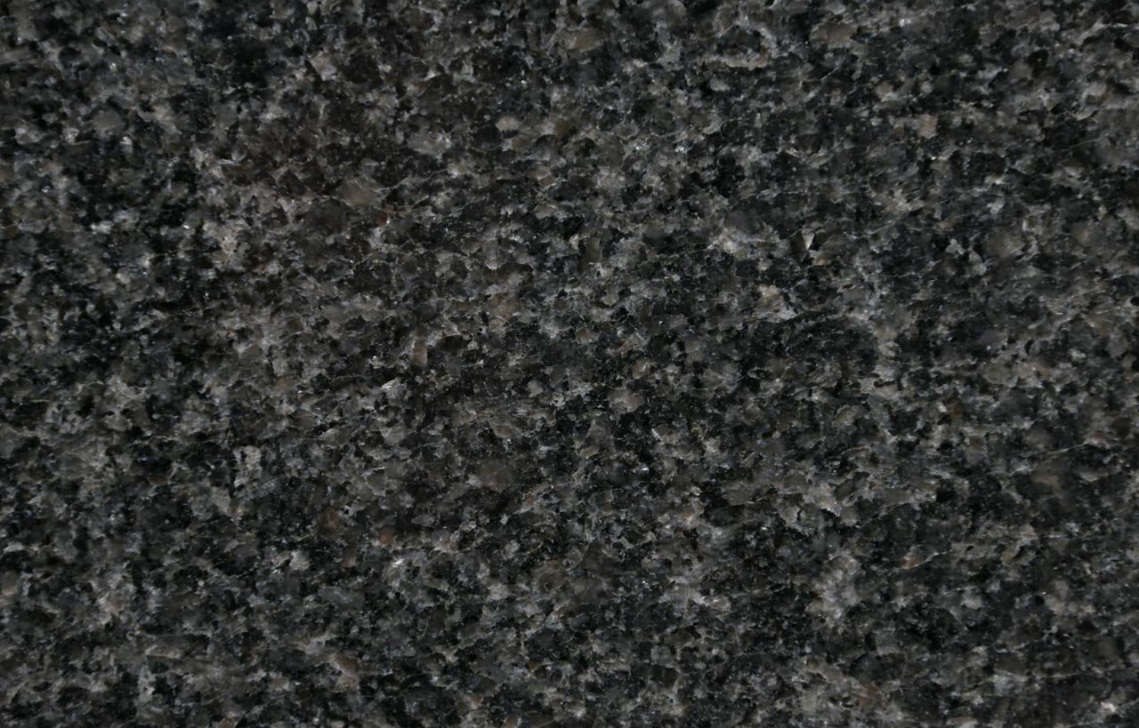 Close up slab photo of Nero Impala Granite showing a dense dark grey speckled pattern and fine grain across the surface.