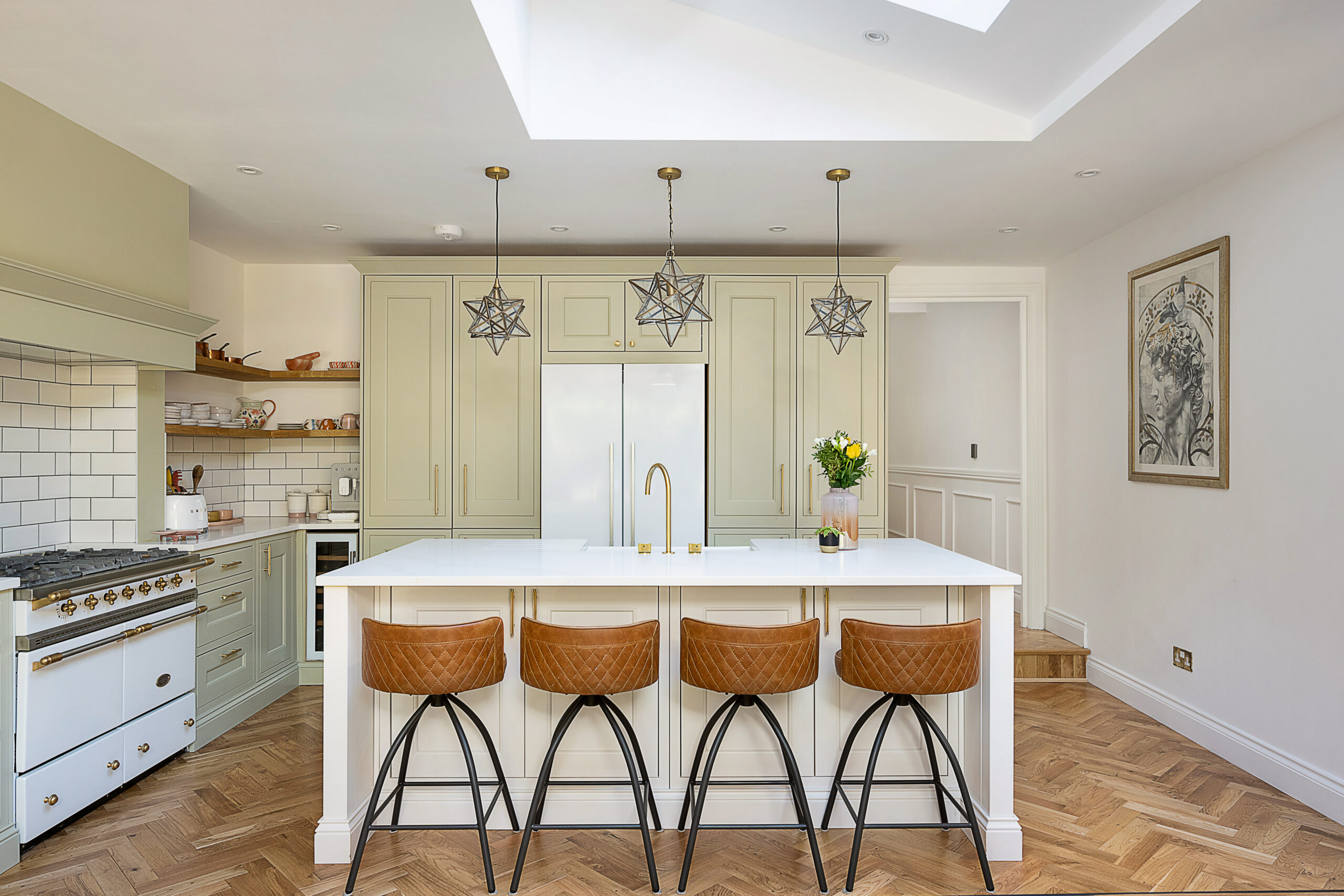Large kitchen island with Eternal Calacatta Quartz worktop and four barstools in a modern bright kitchen
