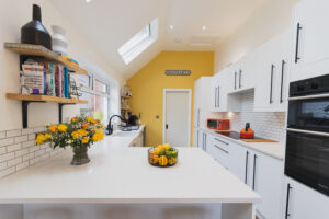 Bright kitchen view with Ice White Quartz worktops on a peninsula and a clean, smooth surface finish