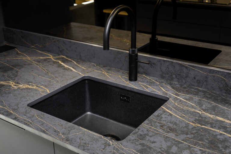 Laurent Porcelain worktop close-up around an undermount sink with a black tap, showing the veining detail across the surface.