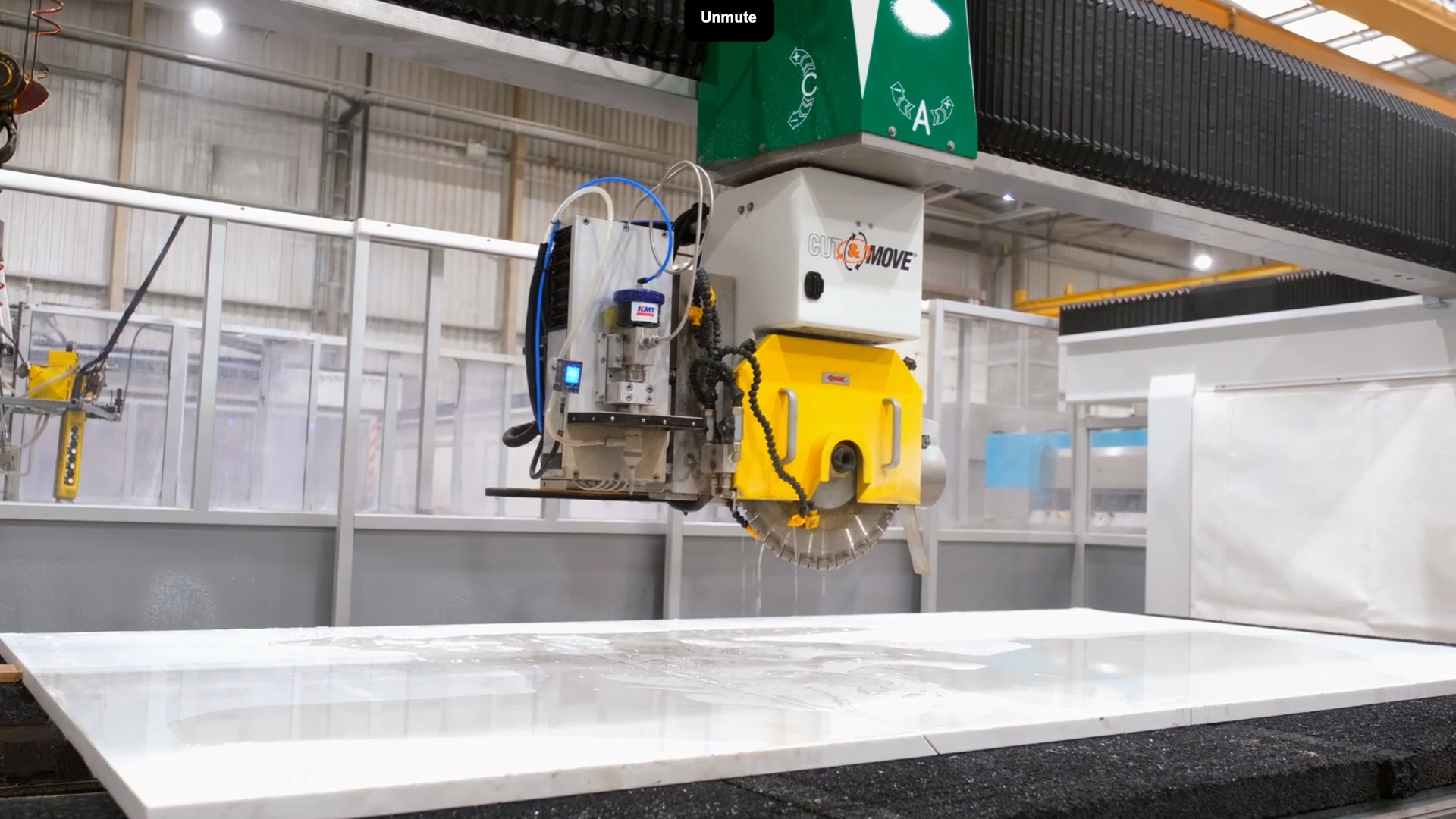 CNC machine cutting a Volakas White Porcelain slab in the Mayfair Worktops workshop, shown during the machining process.