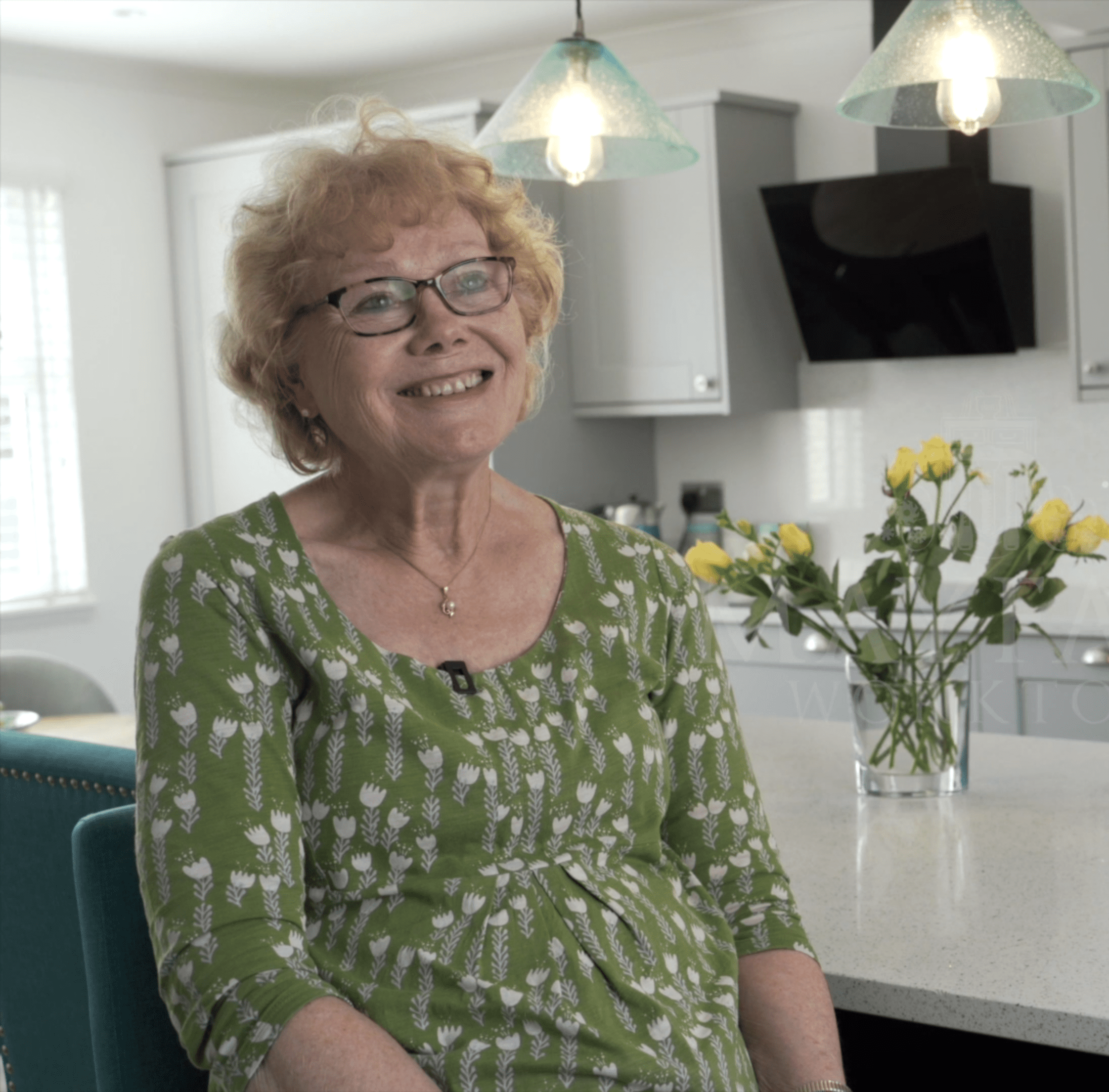 Customer giving a testimonial in her kitchen featuring White Starlight Quartz worktops from Mayfair Worktops