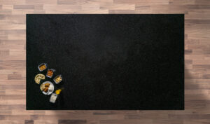 Overhead view of a Star Galaxy Granite worktop showing a dark sparkling fleck pattern, photographed from above with a small styled tray in the corner.