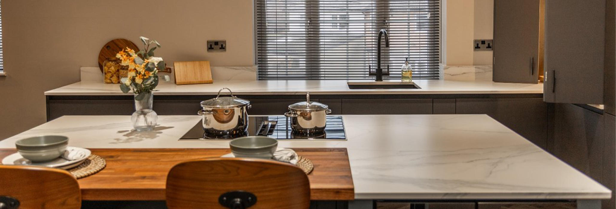 Volakas White Porcelain kitchen worktop installed in a modern space, shown with countertop accessories in the foreground.
