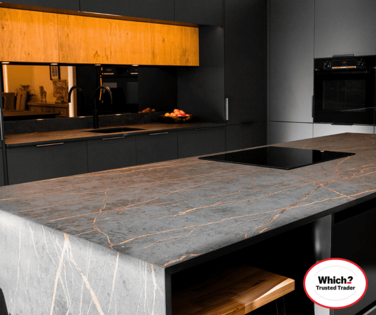 Laurent Porcelain island worktop in a contemporary kitchen, shown in a wider view with grey cabinetry and warm wood wall units.