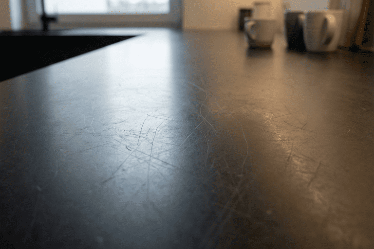 Black Quartz kitchen worktop with fine surface scratches visible under angled light
