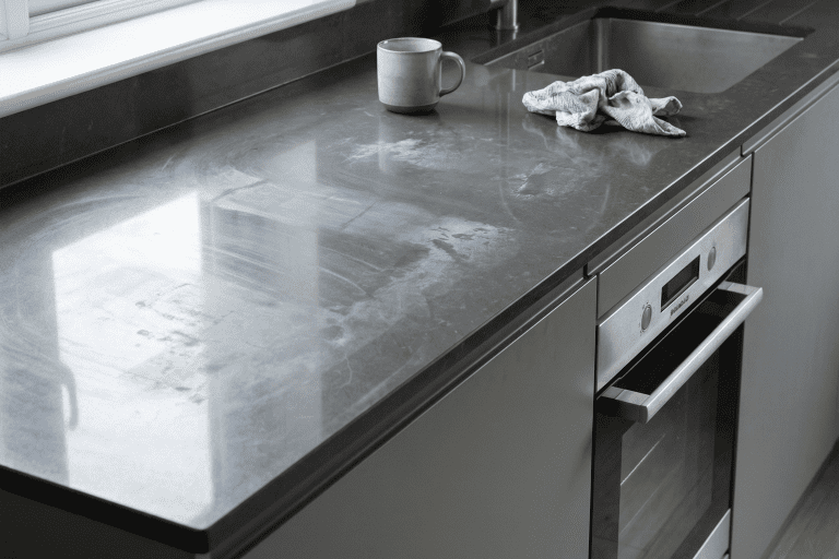 Grey Quartz kitchen worktop with surface marks and dull patches from improper cleaning